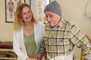 A rehab therapist with a resident in the rehab gym at Primrose Post-Acute
