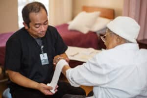 A nurse wrapping a wound of a resident at Primrose Post-Acute